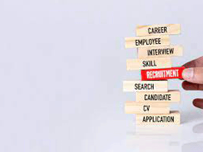 Hand pointing to the word “Recruitment” on a stack of career-related labels.